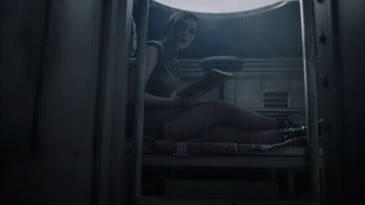 A Woman Sits On The Floor Reading A Book In A Dark Room GIF
