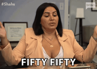A Woman Sitting At A Desk Says Fifty Fifty With Her Hands In The Air GIF