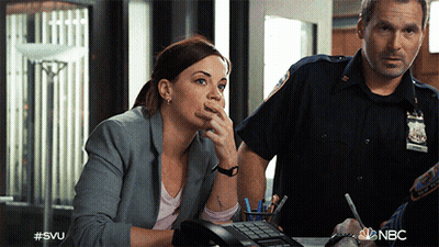 A Woman Sitting At A Desk Talking On A Phone Next To A Police Officer With #Svu Written On The Bottom GIF