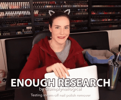 A Woman Sitting At A Desk With A Laptop And The Words " Enough Research " On The Bottom GIF