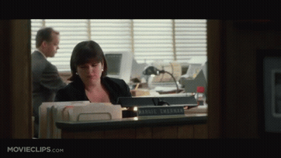 A Woman Sitting At A Desk With A Name Plate That Says Harriet Sherman GIF