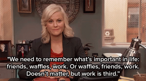 A Woman Sitting At A Desk With A Quote That Says We Need To Remember What 'S Important In Life Friends Waffles Work GIF