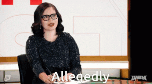 A Woman Sitting At A Desk With Allegedly Written On The Screen GIF