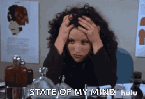 A Woman Sitting At A Desk With Her Hands On Her Head And The Words State Of My Mind GIF