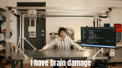 A Woman Sitting At A Desk With The Words I Have Brain Damage On The Bottom GIF