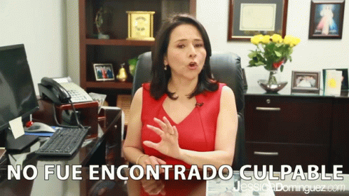 A Woman Sitting At A Desk With The Words No Fue Encontrado Culpable In The Corner GIF