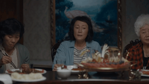 A Woman Sitting At A Table Talking About Raising Kids And Playing The Stock Market GIF