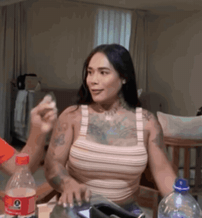 A Woman Sitting At A Table With A Bottle Of Gatorade GIF