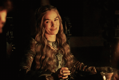 A Woman Sitting At A Table With A Glass Of Wine GIF