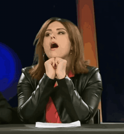 A Woman Sitting At A Table With Her Mouth Wide Open GIF