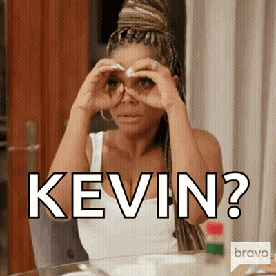 A Woman Sitting At A Table With The Word Kevin Written On Her Face GIF