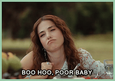 A Woman Sitting At A Table With The Words Boo Hoo Poor Baby Written Below Her GIF