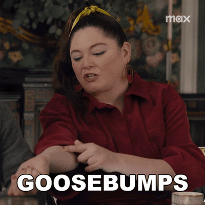 A Woman Sitting At A Table With The Words Goosebumps Written On Her Arm GIF
