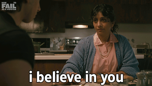 A Woman Sitting At A Table With The Words I Believe In You GIF