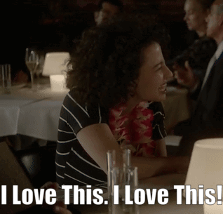 A Woman Sitting At A Table With The Words " I Love This I Love This " GIF