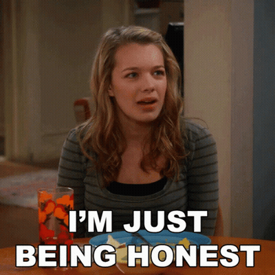A Woman Sitting At A Table With The Words I 'M Just Being Honest Written Below Her GIF
