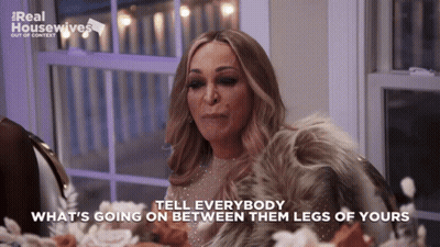 A Woman Sitting At A Table With The Words Tell Everybody What 'S Going On Between Them Legs Of Yours On The Bottom GIF