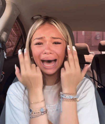 A Woman Sitting In A Car With Her Mouth Open Making A Face GIF