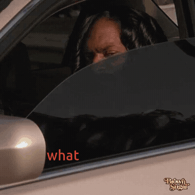 A Woman Sitting In A Car With The Word What Written On The Window GIF