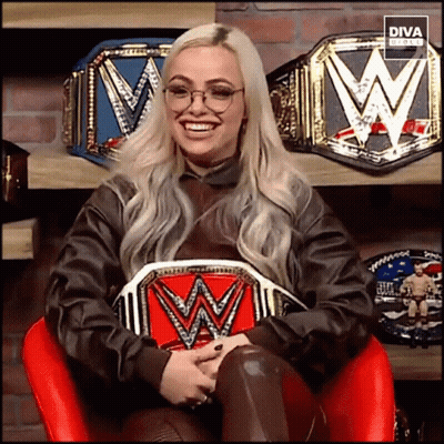 A Woman Sitting In A Chair Holding A W Belt GIF