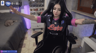 A Woman Sitting In A Chair Wearing A Jersey That Says Lete GIF