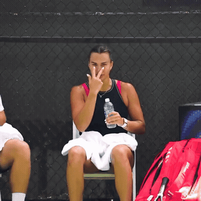 A Woman Sitting In A Chair With A Bottle Of Water GIF