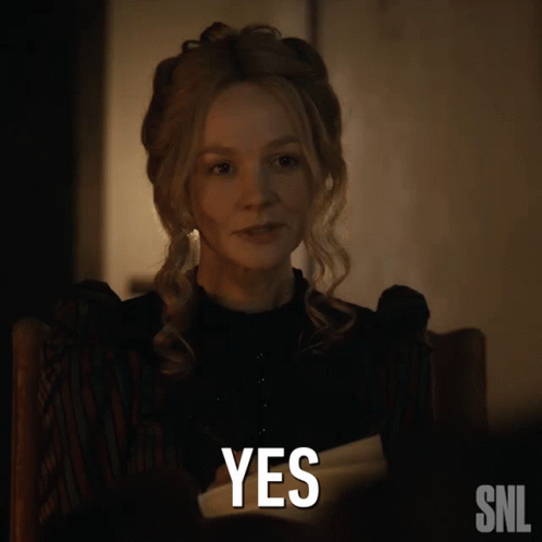 A Woman Sitting In A Chair With A Snl Logo Next To Her GIF