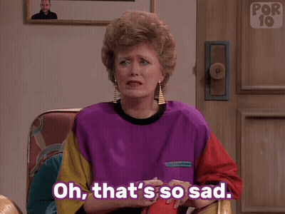 A Woman Sitting In A Chair With Her Hand On Her Face And The Words Oh That 'S So Sad Below Her GIF