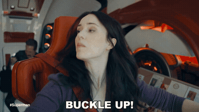 A Woman Sitting In A Chair With The Words Buckle Up Above Her GIF