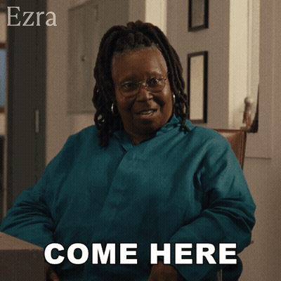 A Woman Sitting In A Chair With The Words Come Here Behind Her GIF