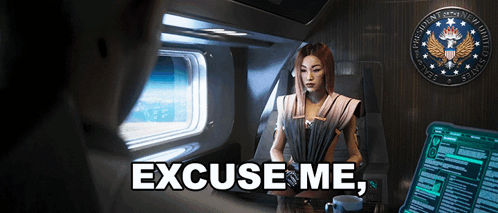 A Woman Sitting In A Chair With The Words Excuse Me On The Bottom Right GIF
