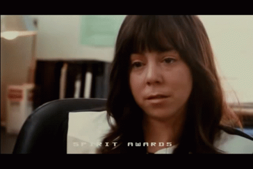 A Woman Sitting In A Chair With The Words Spirit Awards On The Screen Behind Her GIF