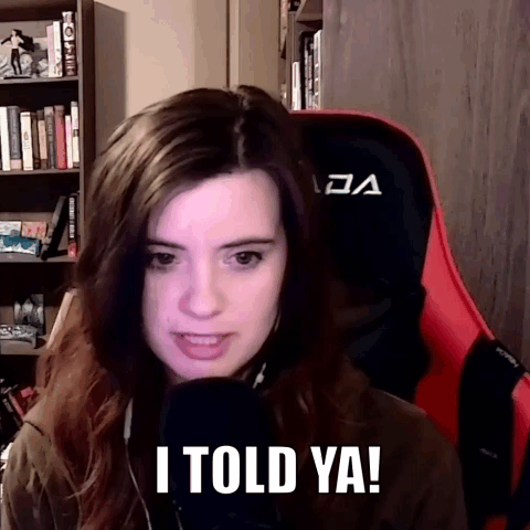 A Woman Sitting In A Red And Black Gaming Chair Says I Told Ya ! GIF