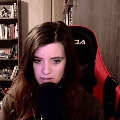 A Woman Sitting In A Red Chair With The Letter A On The Back GIF