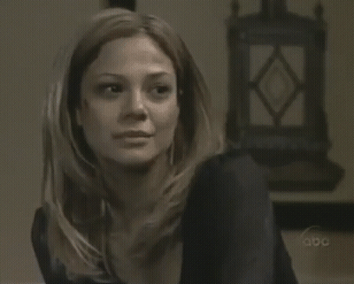 A Woman Sitting In Front Of A Clock That Says Abc GIF