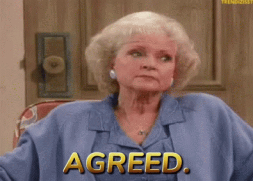 A Woman Sitting In Front Of A Door With The Word Agreed On Her Shirt GIF