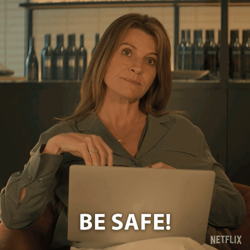 A Woman Sitting In Front Of A Laptop That Says Be Safe On The Screen GIF