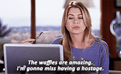 A Woman Sitting In Front Of A Laptop With A Fork In Her Hand And The Words " The Waffles Are Amazing " GIF