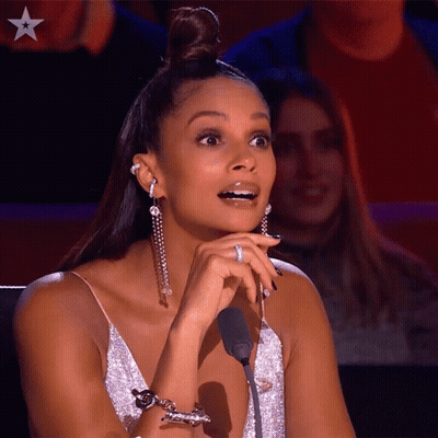 A Woman Sitting In Front Of A Microphone With A Star On The Bottom Left GIF