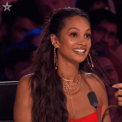 A Woman Sitting In Front Of A Microphone With The Word Never Behind Her GIF
