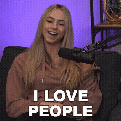 A Woman Sitting In Front Of A Microphone With The Words " I Love People " Above Her GIF