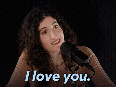 A Woman Sitting In Front Of A Microphone With The Words I Love You Above Her GIF