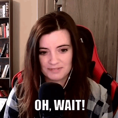 A Woman Sitting In Front Of A Microphone With The Words Oh Wait Written On Her Face GIF