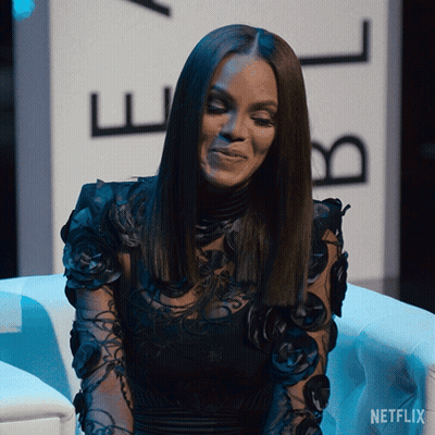 A Woman Sitting In Front Of A Netflix Sign GIF