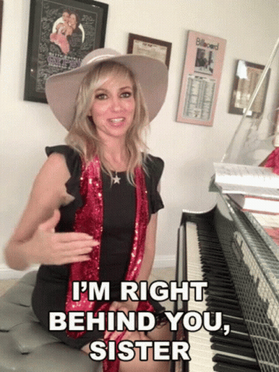 A Woman Sitting In Front Of A Piano With The Words I 'M Right Behind You Sister GIF