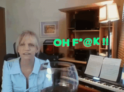 A Woman Sitting In Front Of A Piano With The Words Oh F @ K Written In Green Letters GIF