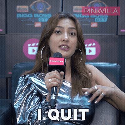 A Woman Sitting In Front Of A Pinkvilla Sign Holding A Microphone And Saying I Quit GIF