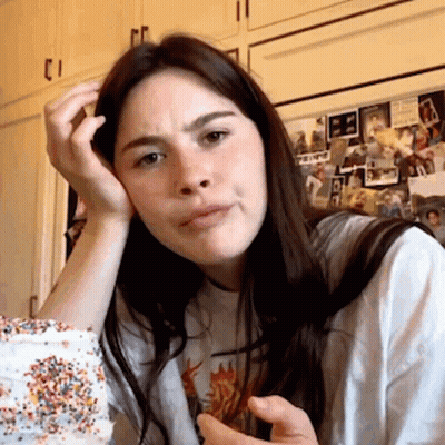 A Woman Sitting In Front Of A Refrigerator With A Picture Of A Man On It That Says ' A ' On It GIF