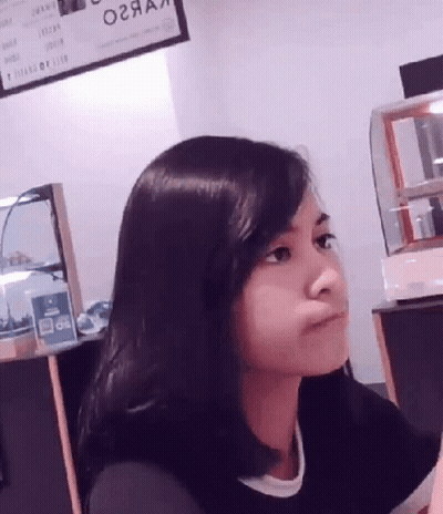 A Woman Sitting In Front Of A Sign That Says ' O2aa ' On It GIF
