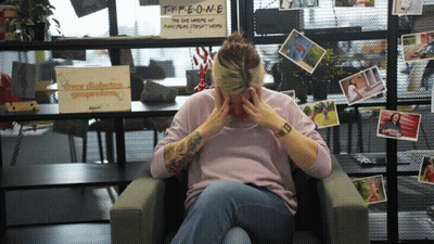 A Woman Sitting In Front Of A Sign That Says Type One On It GIF